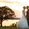 bride and groom holding hands with sunset
